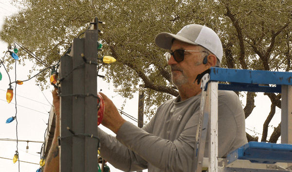 aLand Mike putting up lights PRINT